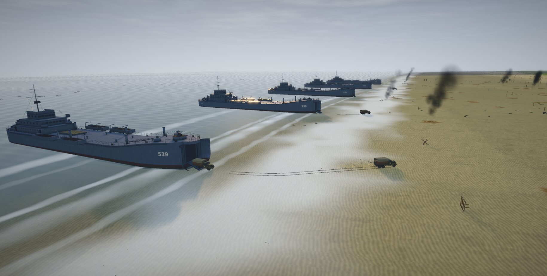 A line of LSTs beached on the sand, trucks rolling off their ramps