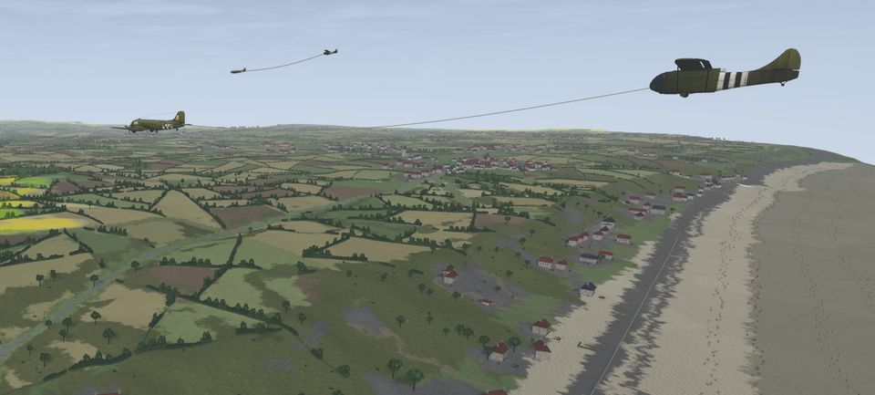 A glider on tow over the Normandy coast